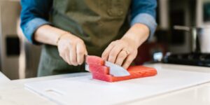 An active older adult preparing a healthy, protein-rich meal in a bright kitchen.