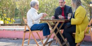 Two active seniors playing table tennis in a bright community center.