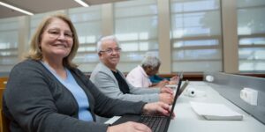 A diverse group of seniors using digital technology in a modern community space.