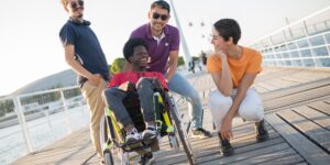 A group of older adults enjoying a safe, accessible riverfront promenade during sunset.