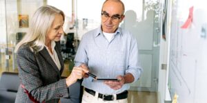 A professional senior couple collaborating on a digital project in a home office.