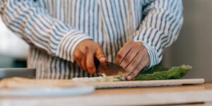 A healthy senior preparing a meal with fresh, nutrient-dense ingredients in a bright kitchen.