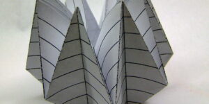 Close-up of hands folding origami paper.