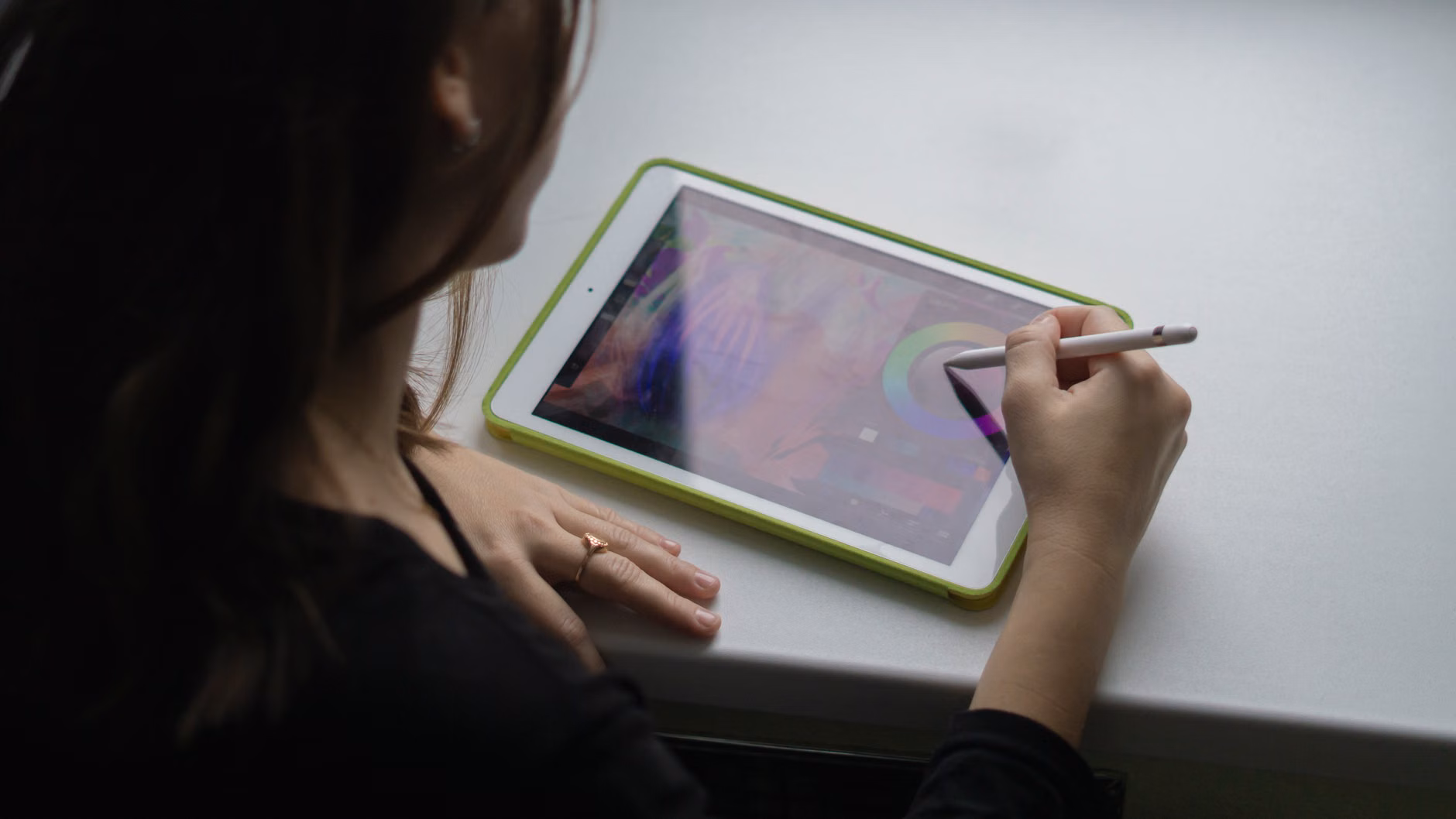 Close-up of a hand using a digital stylus on a tablet screen.