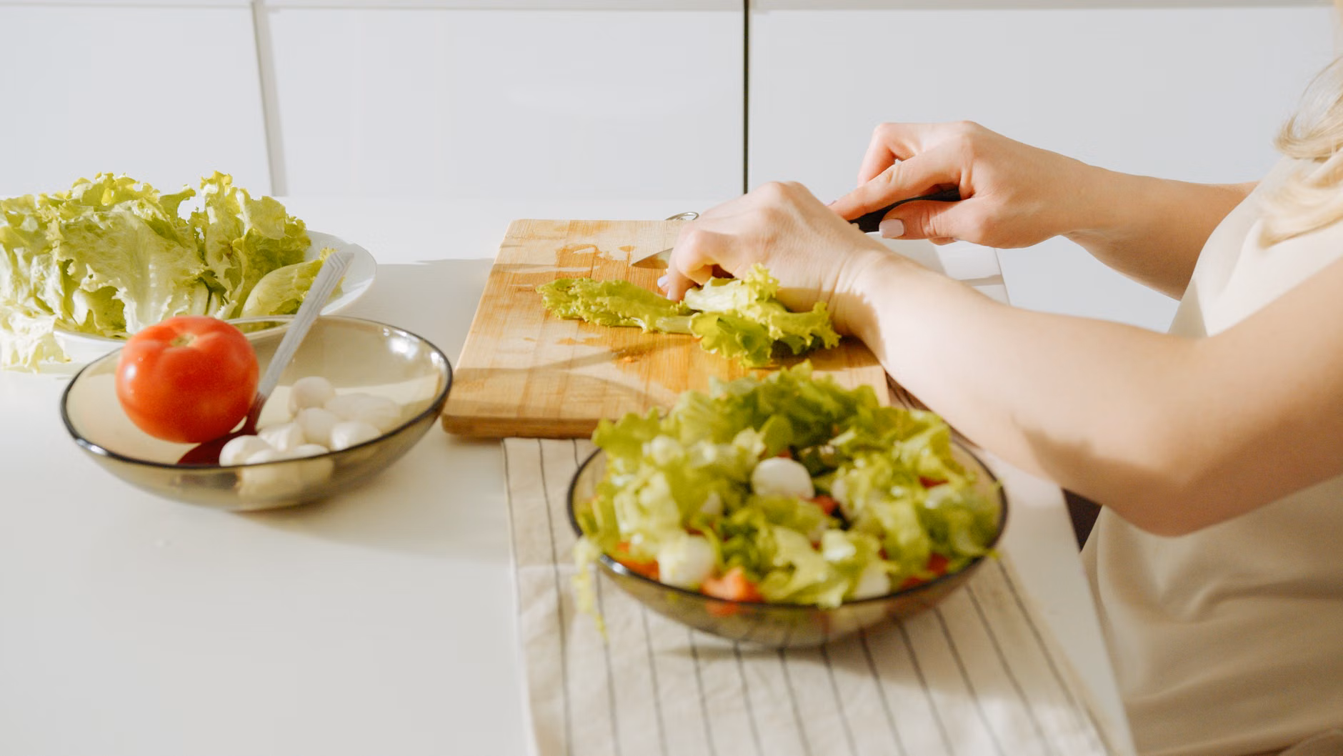 Collagen and Vitamin C: A Practical Guide to Skin Resilience After 60 2 Hands preparing a nutritious, colorful salad with fresh vegetables.