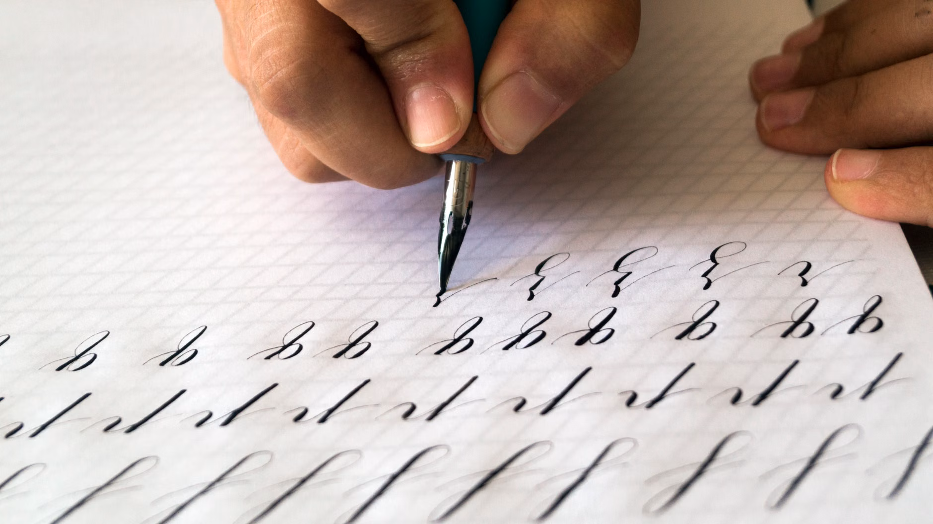 An individual practicing rhythmic pen strokes on grid paper.