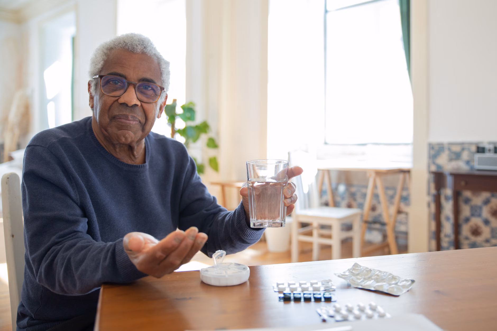 Smart Home Voice Assistants in 2026: A Practical Guide for Independent Living 2 An older adult setting a medication reminder via a voice-activated smart device in the kitchen.