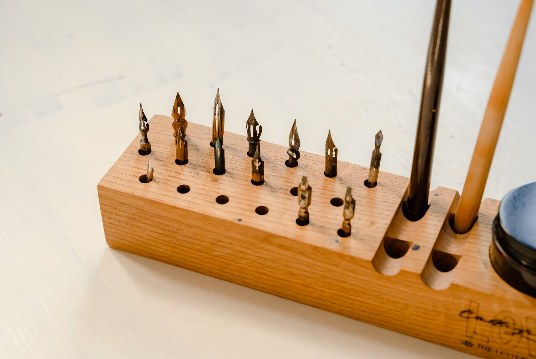 A collection of calligraphy tools including ink bottles and nibs on a desk.