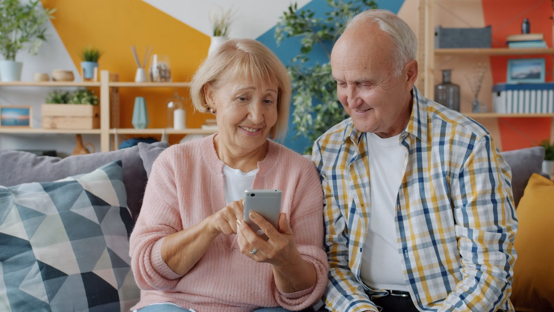 An older couple reviewing safety settings on their digital devices.