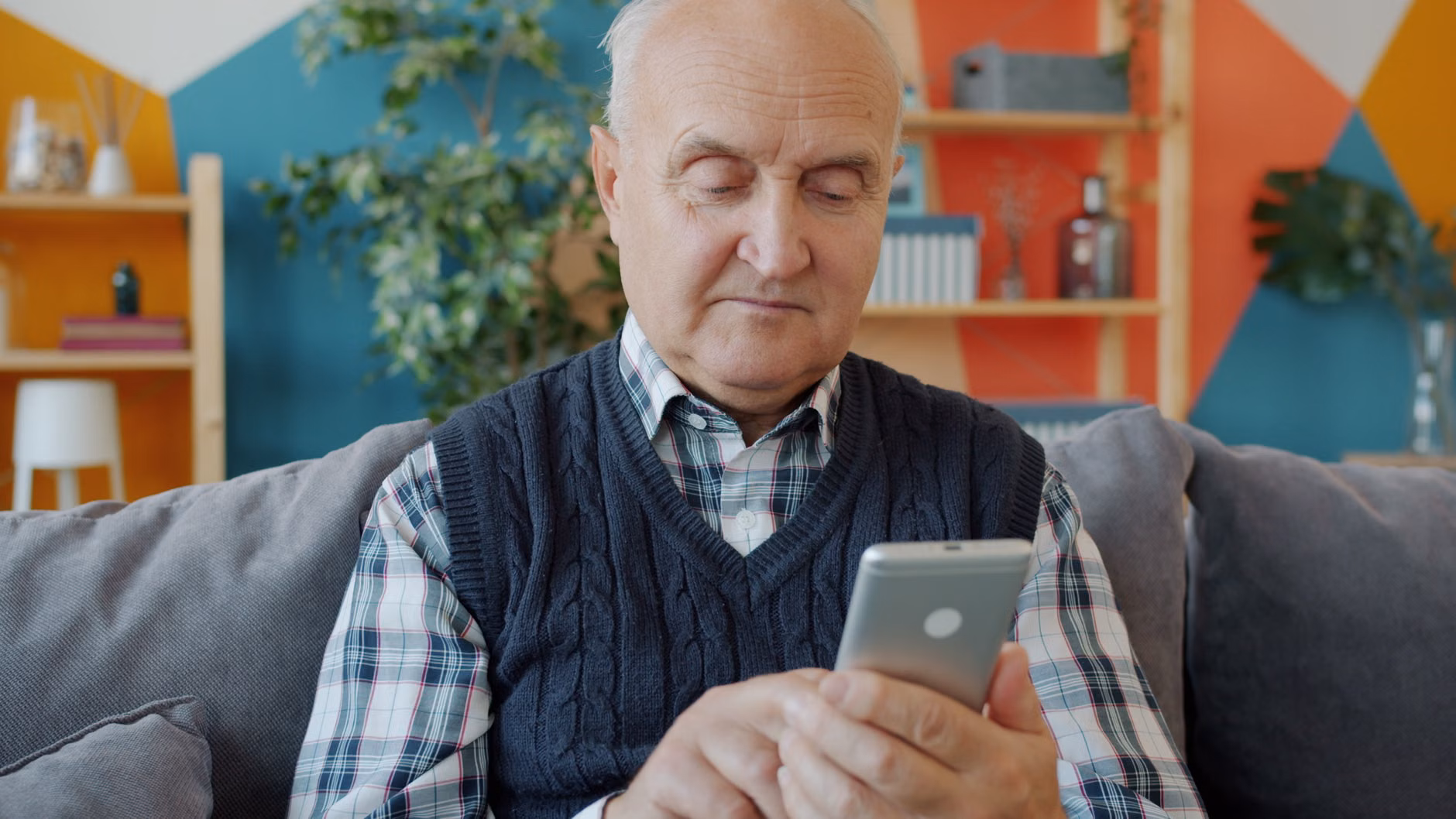 An older adult adjusting digital sound settings on a smartphone.