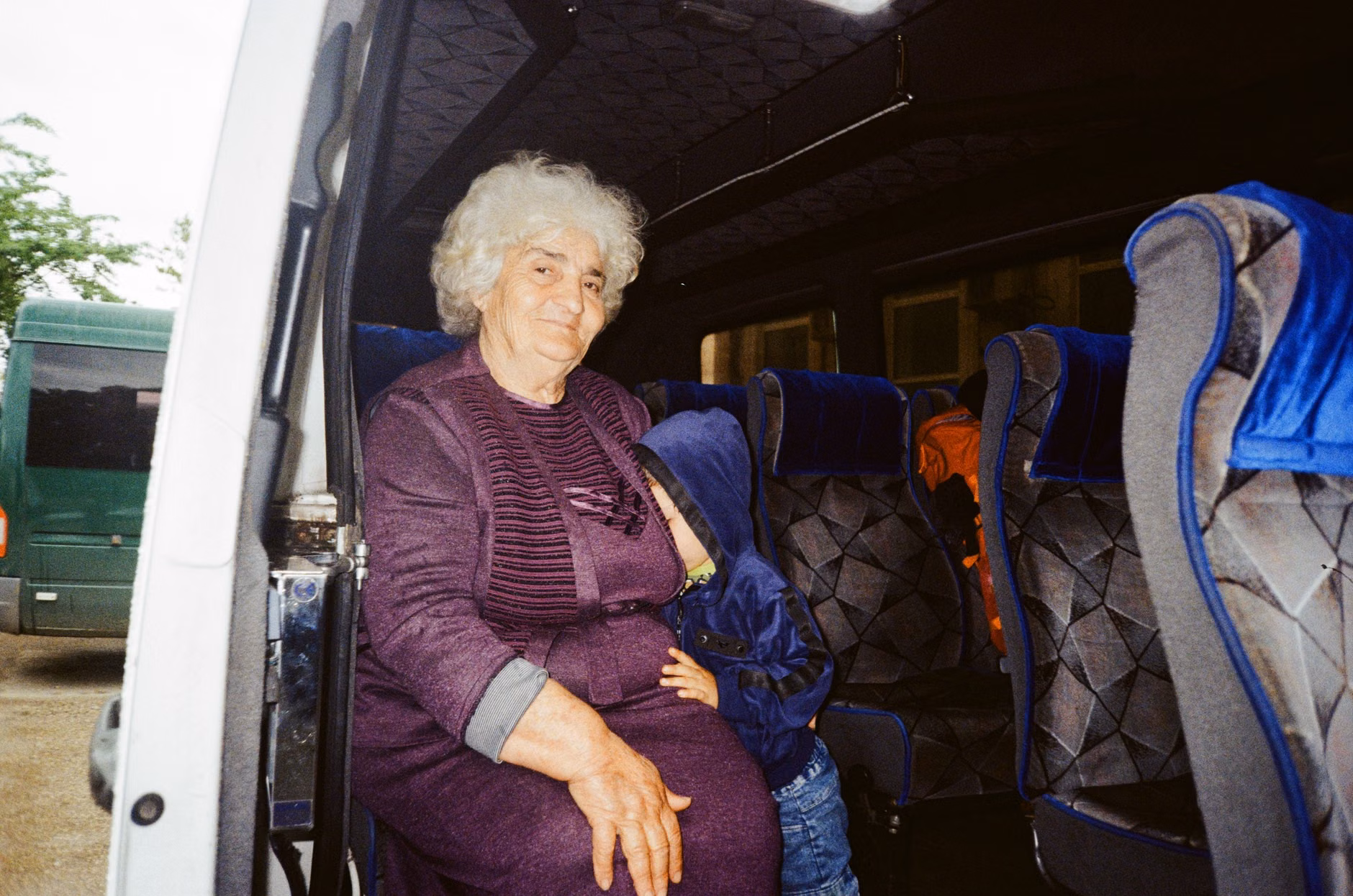 Older adult seated comfortably on a modern, accessible low-floor bus.