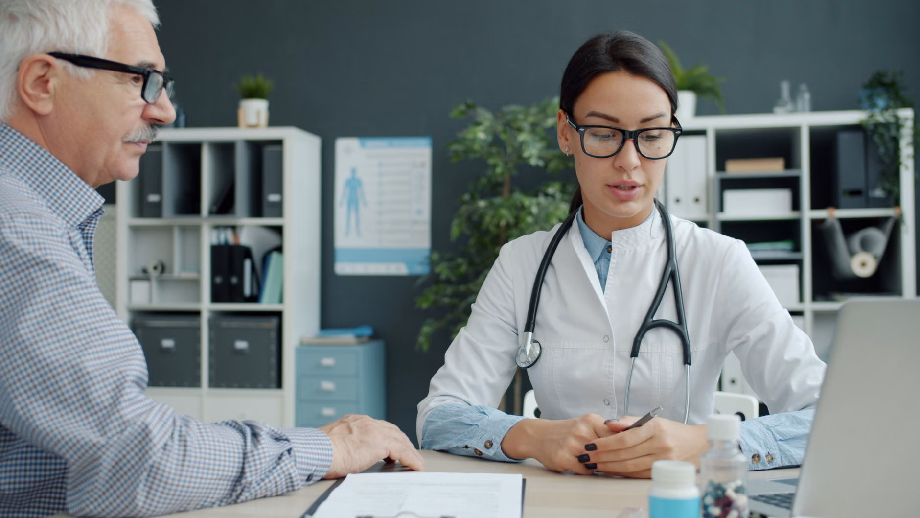 A doctor and an older patient discussing health in a clinical setting.