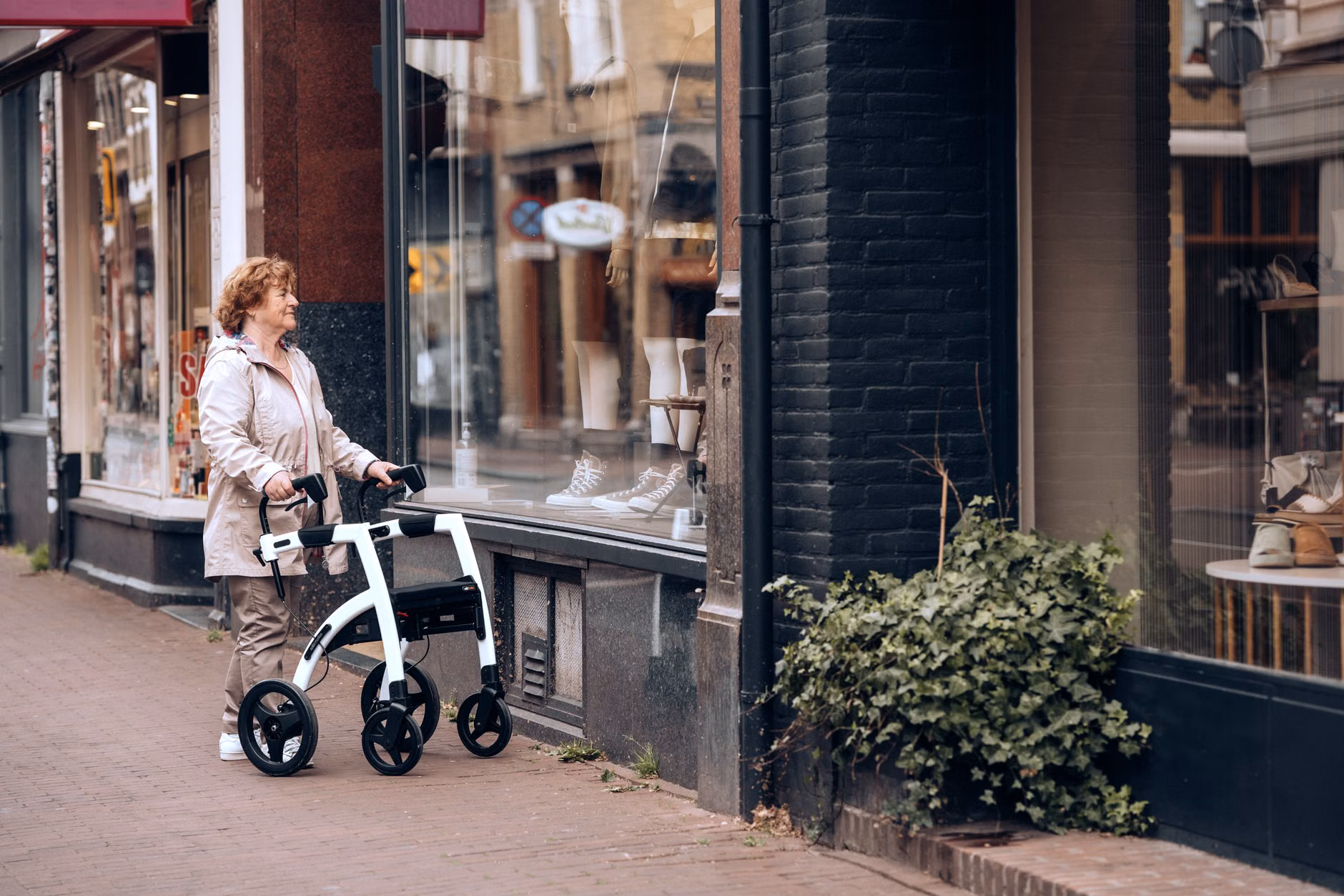 An older adult walking safely across a street with accessible tactile curb ramps.