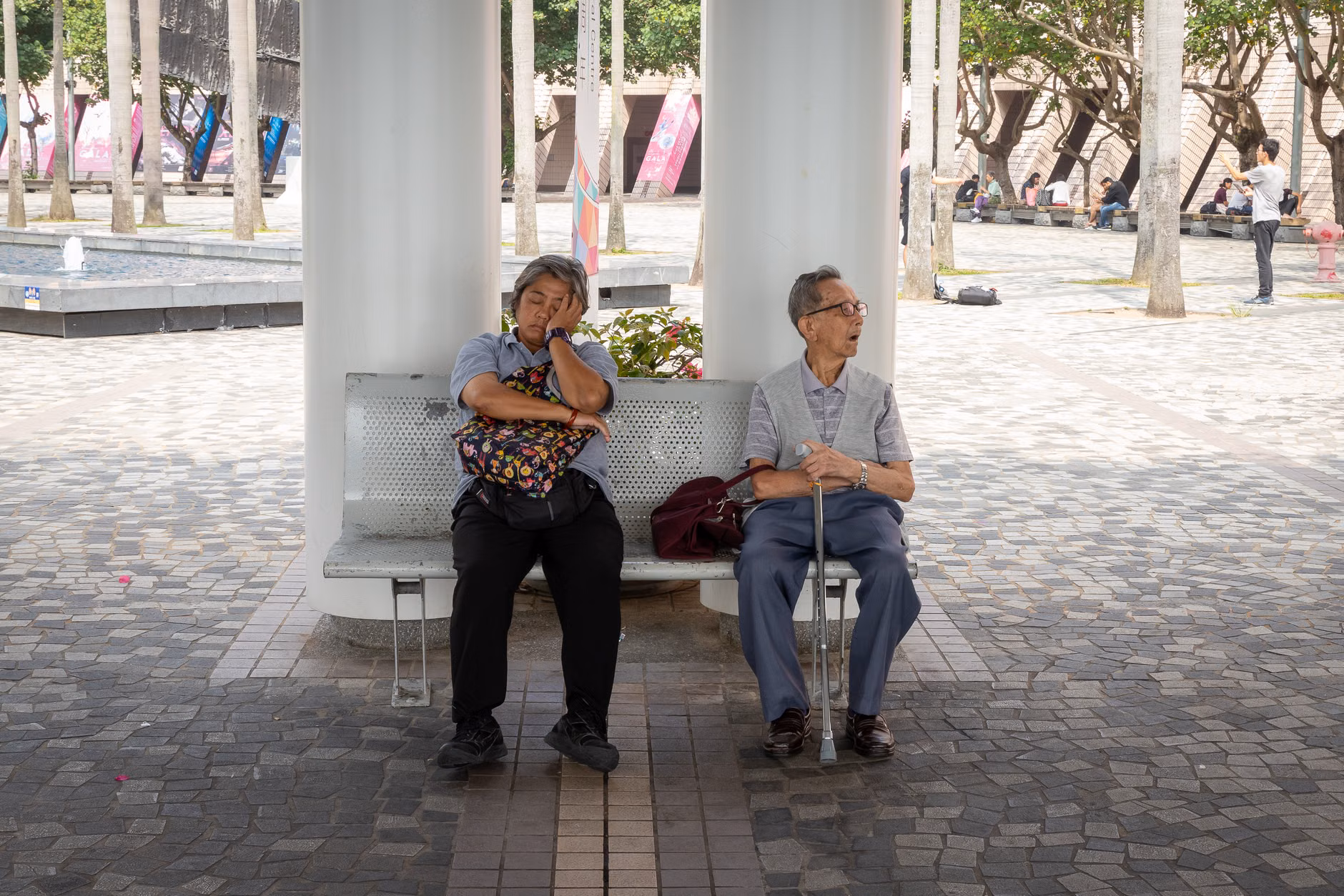 A senior traveler resting on a bench while navigating a city.