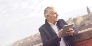 A senior couple using a tablet to access hotel services in a comfortable room.
