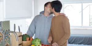 A couple preparing a nutritious meal in a sunlit kitchen to promote healthy aging.