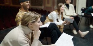 A diverse group of seniors rehearsing a play on a community theater stage.