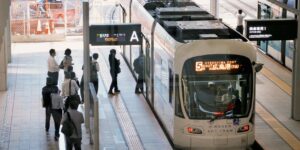 A modern low-floor electric tram arriving at an accessible city station.