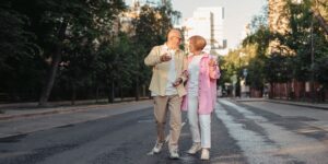 A group of active seniors walking and talking together in a park setting.