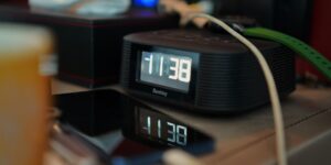 A smartphone on a hotel bedside table displaying a soundscape app to aid sleep.