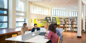 A diverse group of older adults collaborating on genealogy research in a library.