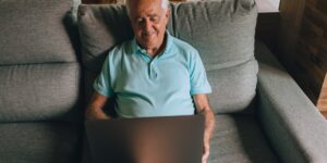 An older adult practicing seated ankle circles in a comfortable home environment.