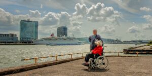 An active senior couple looking out at a cruise port from the deck of a ship.