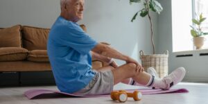 An active senior performing a seated torso-twist exercise for spinal mobility.