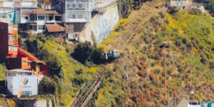A modern funicular climbing a steep historic hillside.