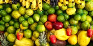 A selection of fresh, colorful fruits and vegetables rich in Vitamin C arranged on a kitchen counter.