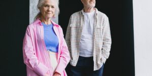 An older couple standing confidently on a modern, accessible high-speed train platform.