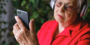 An older adult using a digital museum interface on a tablet.