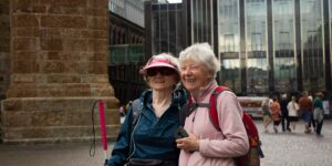 A senior couple enjoying a walk in a historic city, carrying lightweight gear.