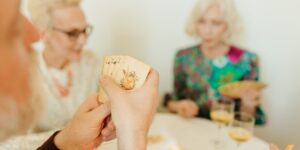 A group of seniors playing bridge in a bright, modern community center.