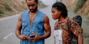 A couple using a smartphone for navigation in a historic city square.
