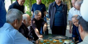 Diverse group of seniors playing chess in a bright, modern community center.