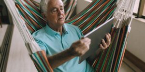 A confident older adult managing digital finances on a tablet at home.