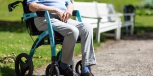 An older adult performing seated ankle exercises in a comfortable home environment.