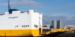 A modern river cruise ship docked with an accessible ramp in place.