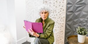 An older adult comfortably using a tablet in a modern home setting.