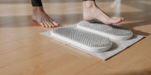 An older adult practicing foot dexterity exercises in a bright, comfortable home environment.