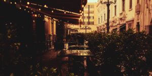 A scenic, accessible historic plaza cafe terrace bathed in warm sunlight.