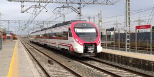 Modern high-speed train arriving at a station platform.