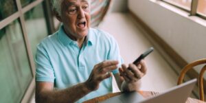 An older adult engaging in digital photo restoration on a computer, showing before-and-after versions of a vintage photograph.