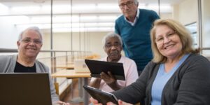 A senior adult reading on a tablet in a modern library.