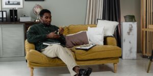 A person comfortably managing finances on a tablet in a modern home office.