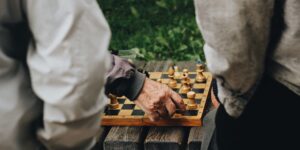 Two seniors playing chess in a bright, welcoming community center.