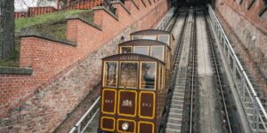A scenic view of a modern funicular climbing a hillside toward a city.