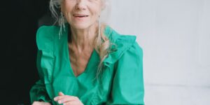 A senior individual confidently using voice-activated technology in a modern, comfortable home office.
