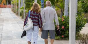 An elderly couple strolling through a bright, accessible historic botanical garden.